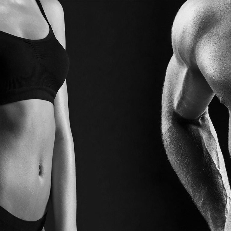 The colorless image of torso of attractive male and female bodys on black studio background.